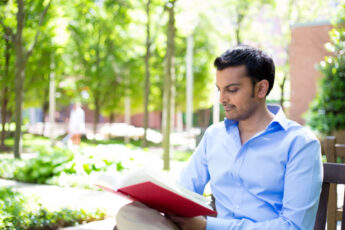 shutterstock_196371398 Man Reading in Scenic Park