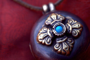 Close-up,Of,A,Tibetan,Gau,On,Red,Fabric